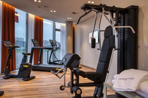 A gym with exercise equipment, a treadmill, and a mirror. -  Intercityhotel Amsterdam Schiphol Airport (Hoofddorp)