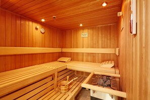 A sauna with wooden benches, a wooden bench with a towel, and a wooden bench with a towel. -  Intercityhotel Amsterdam Schiphol Airport (Hoofddorp)