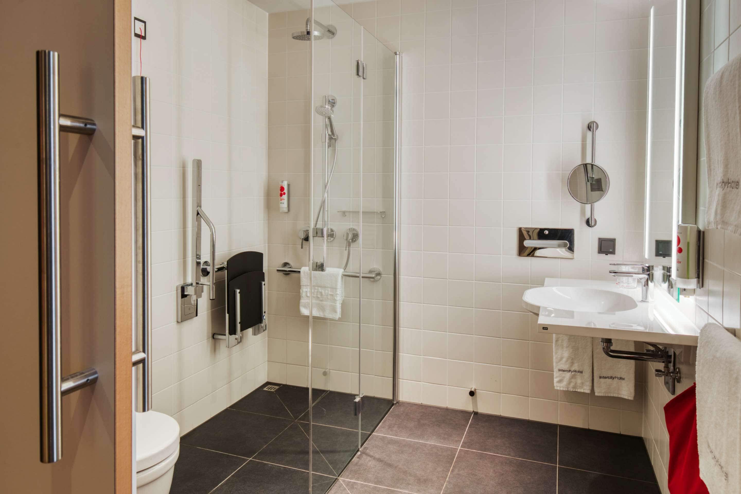 Une salle de bain moderne avec une douche à parois de verre, un lavabo blanc et des toilettes.