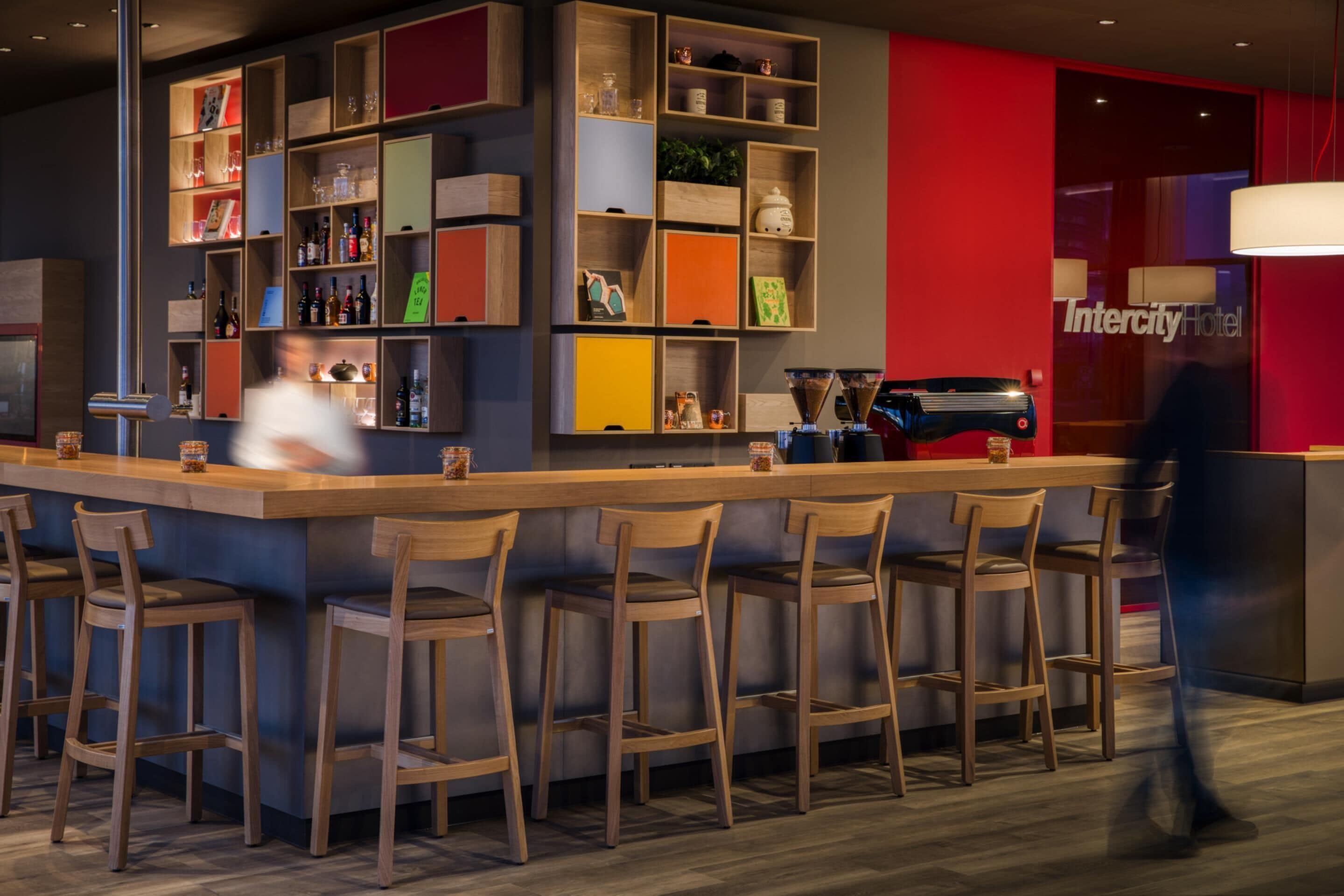 A bar area with multiple stools, shelves with various items, and a visible sign for Intercity Hotel.