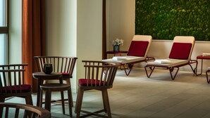 A room with wooden chairs and tables, a green wall, and a window with curtains. -  Intercityhotel Amsterdam Schiphol Airport (Hoofddorp)