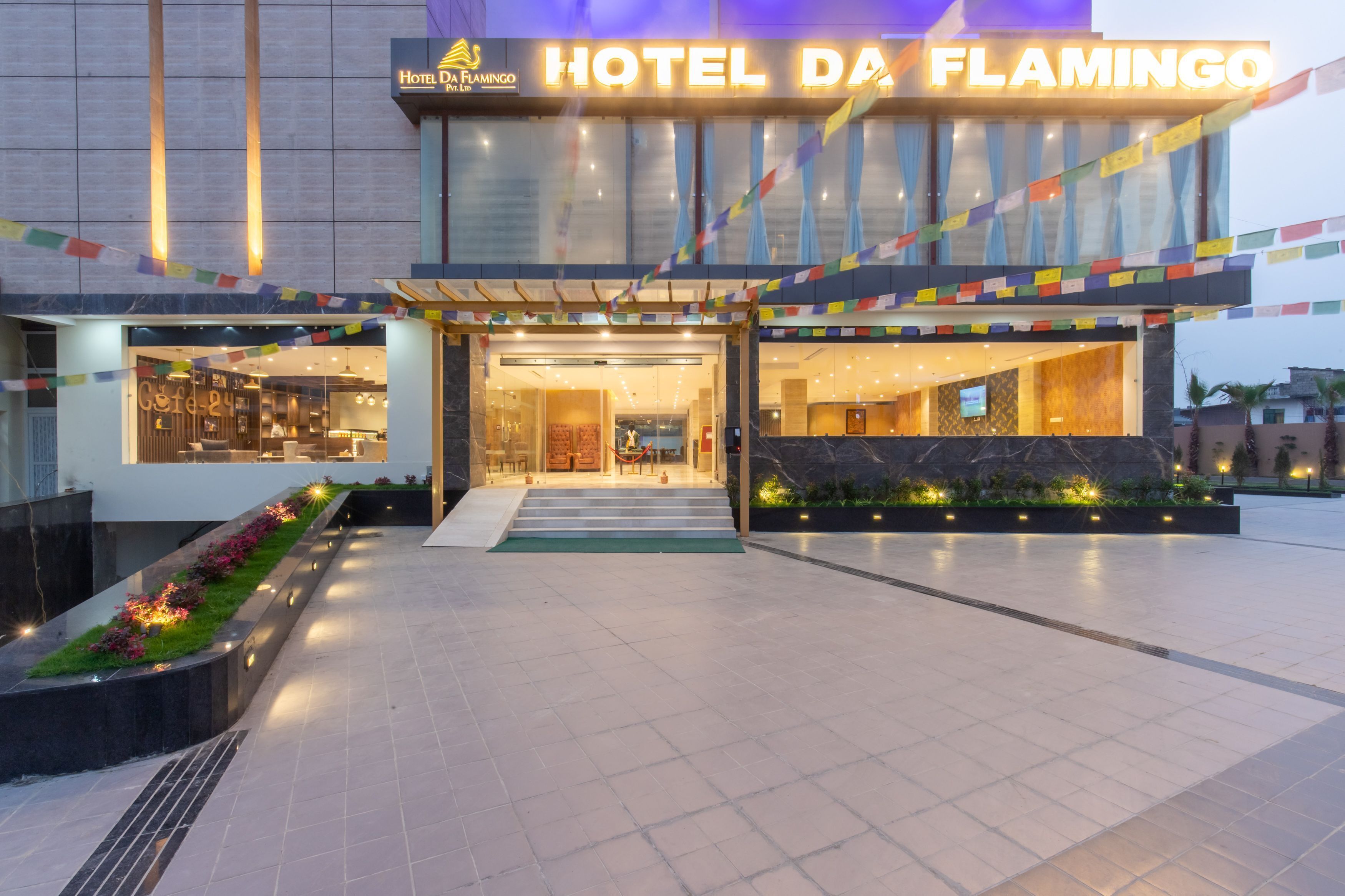 The exterior of Hotel Da Flamingo with a modern facade, a well-lit entrance, and a visible restaurant area.