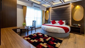 Una habitación de hotel moderna con una cama grande, un escritorio y una silla.
