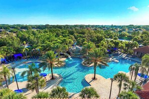 A resort with a large central pool surrounded by palm trees and lounge chairs. - Elegant Home w/ Ice Themed BR, Bowling, Karaoke RM, Theater & Gym - Near Parks (Davenport)