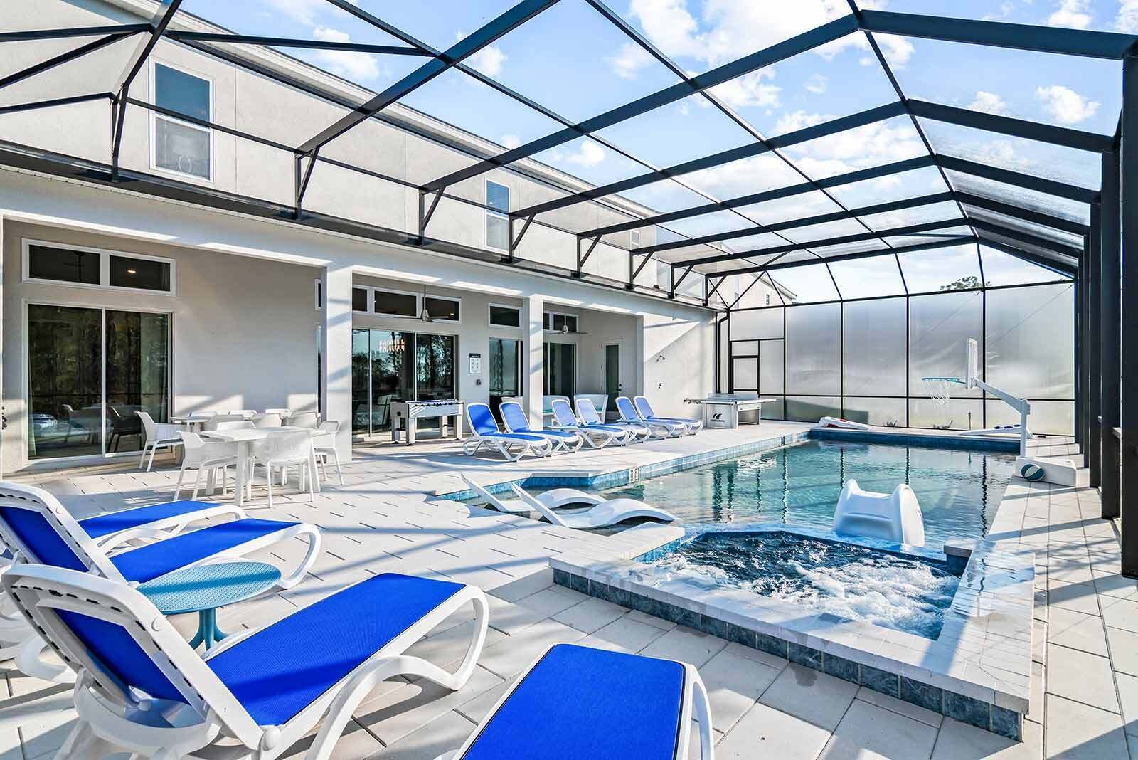 A rooftop pool area with lounge chairs and a hot tub.