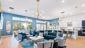A modern living room with blue sofas, a coffee table, and a stone accent wall. - Super Villa Near Disney w Sci-Fi Arcade, Space Theme BR, Theater, Gym, Spa Pool (Davenport)