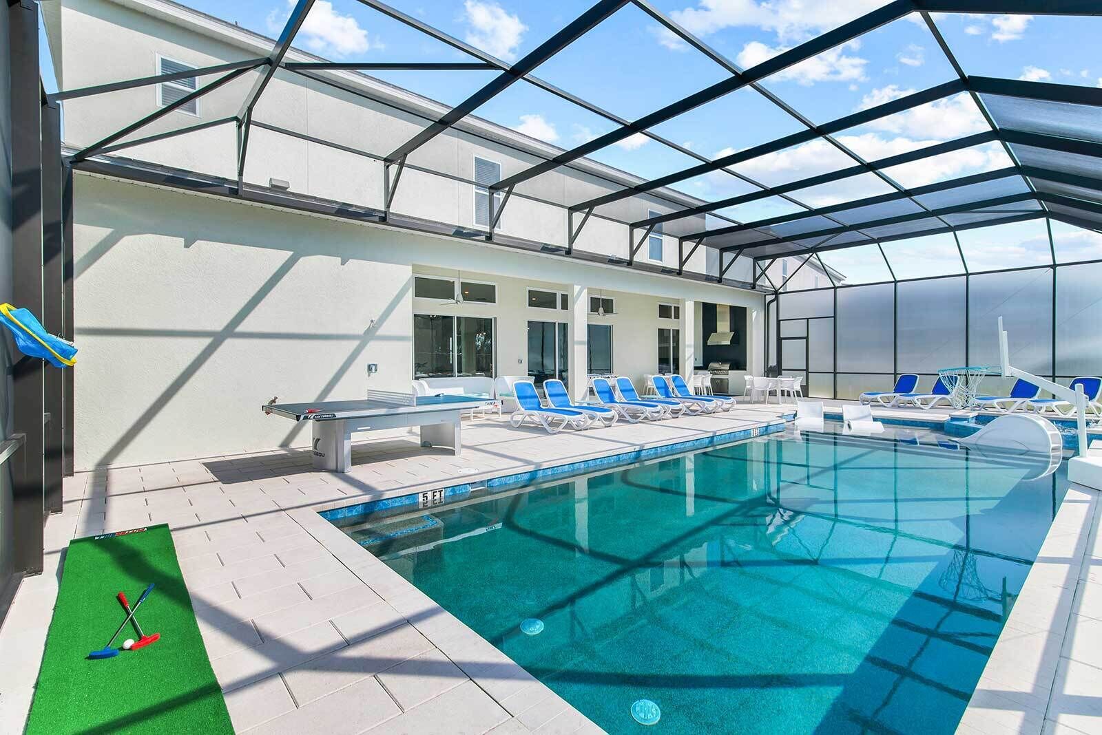 A swimming pool with lounge chairs and a sunshade structure.