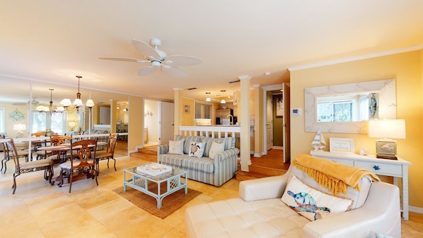A spacious living room with a dining area, a balcony, and a kitchen in the background. - Beautifully Updated One Bedroom Villa Great for a Couples Getaway! (Hilton Head)