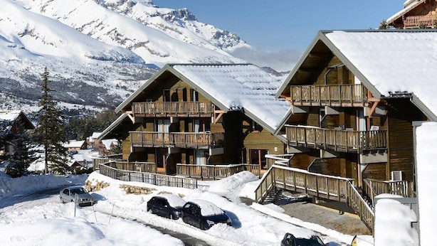A snow-covered mountain lodge with wooden balconies and a clear view of snow-capped peaks. - 200m from ski slopes, balcony, parking, tv, ski locker, 25m², La Joue du Loup (Agnières-en-Dévoluy)