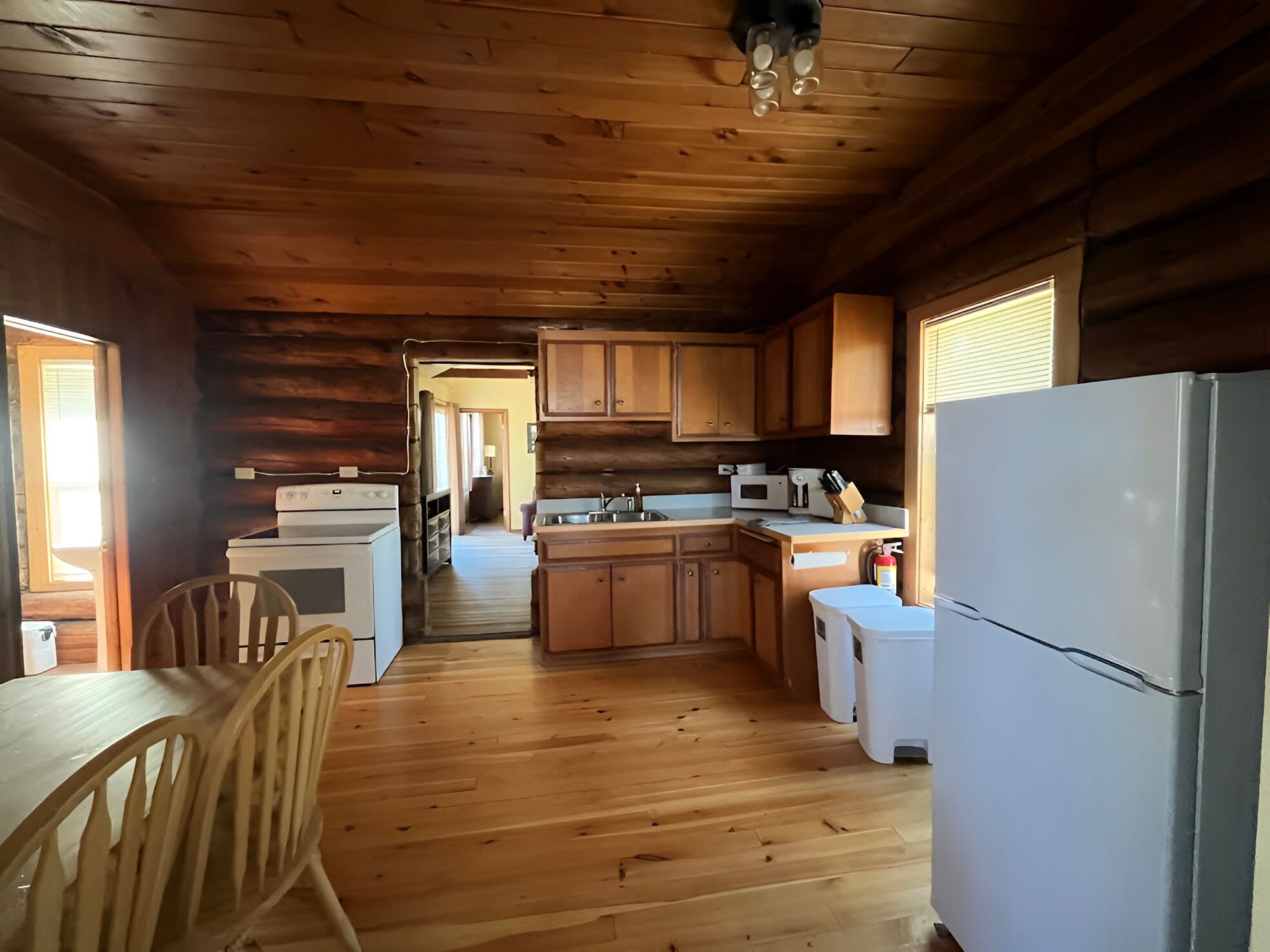 L’intérieur d’une cabane en bois comprend un coin cuisine équipé d’une cuisinière, d’un four à micro-ondes, d’un évier et d’un réfrigérateur.