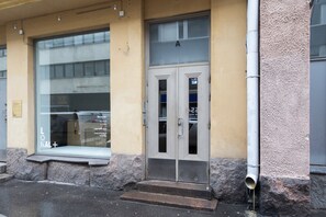 Una entrada de edificio con puerta de cristal y ventana.