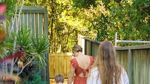 A pathway leading to a wooden gate surrounded by lush greenery.