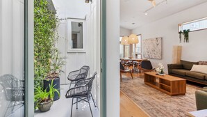 A modern interior with a dining area, a sofa, and a ceiling fan. - Paradise | Private Hot Tub + Shared Heated Pool (New Orleans)