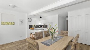 Enjoy meals in this dining area with a wooden table and wicker chairs.