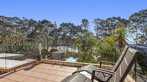 Relax on the rooftop terrace with a view of the pool and lush greenery.