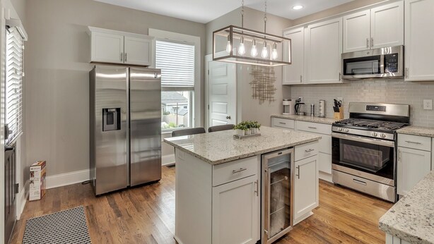 A modern kitchen with stainless steel appliances, white cabinetry, and a central island. - Recently Renovated Home In The Heart Of Bellevue! 2 Bedroom Home by RedAwning (Bellevue)