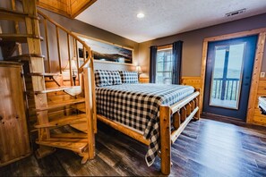 A wooden staircase leading to a bedroom with a bed, a nightstand, and a window with curtains. - Ain't No Mountain High Enough 1 Bedroom Cabin by RedAwning (Sevierville)