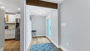A narrow hallway with a wooden ceiling, a blue door, and a small stool. - Beautiful Villa With First Class Amenities on Charlotte Harbor, Orlando Villa 5584 (Punta Gorda)