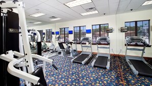 A gym with treadmills, elliptical machines, and weightlifting equipment. - Charming Townhome Sleeps 8 5577 (Kissimmee)