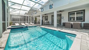 A swimming pool with a glass ceiling, lounge chairs, and wicker furniture. - Perfect 8 Bedroom Villa on Champions Gate, Orlando Villa 5483 (Kissimmee)