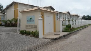 A residential building with a sign reading "Mont Carmelo Residencial." - Porto Seguro-Condomínio Mont Carmelo Ap 5A (Porto Seguro)
