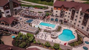 A hotel with multiple swimming pools, outdoor seating areas, and a landscaped garden. - Hillside Getaway Ski-In Ski-Out Retreat in Ellicottville, NY Sleeps 4 (Ellicottville)
