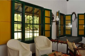 Relax in this traditional room with a comfortable bed, two chairs, and a small table.