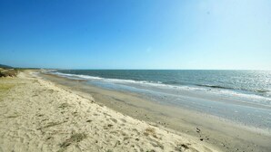 A beach with a clear sky and calm sea.