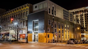 A modern building with a large entrance, a visible sign for a restaurant, and a street intersection. - Finnley Boutique King Room (Grand Rapids)