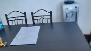 A dining table with four chairs, a water dispenser, and a piece of paper on the table. - Best west $ (Kiambu County)