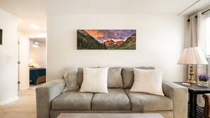 Ein Wohnzimmer mit Sofa, Couchtisch, einem Gemälde und einer Lampe.