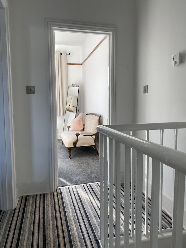 A hallway with a striped carpet leading to a bedroom. - Cosy period house near the seafront (Ramsgate)