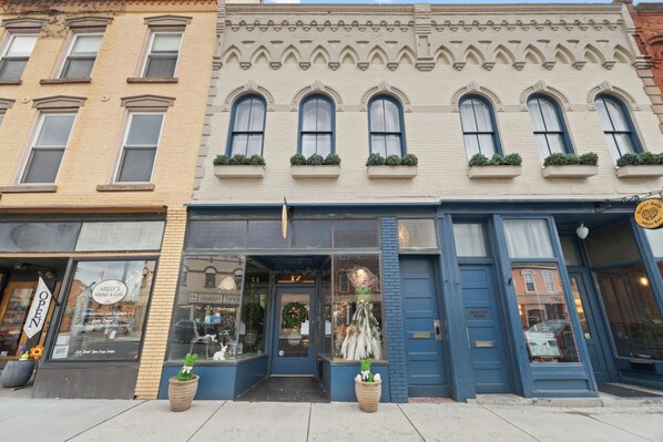 A row of multi-story buildings with storefronts, including a cafe with a visible sign.