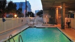 A swimming pool with a diving board, surrounded by a wooden deck and a fence. - 8 BED 5 BATH Condo - Perfect for Multi-Family Vacations - Summer Week Deals (North Myrtle Beach)