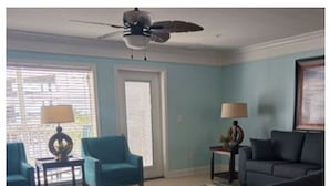 A living room with a sofa, armchairs, a coffee table, a rug, and a ceiling fan. - 8 BED 5 BATH Condo - Perfect for Multi-Family Vacations - Summer Week Deals (North Myrtle Beach)