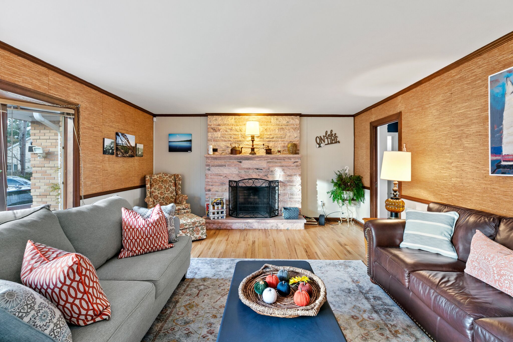 A living room with a fireplace, a sofa, a coffee table, and a lamp.