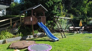 A playground with a slide, swing set, and trampoline. - Apartment Englmari for 5 pers. with 60 sqm in St. Englmar (Sankt Englmar)