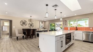 A modern kitchen with a central island, white cabinetry, and stainless steel appliances. - The Valley View- Heated Pool/ Hiking/ Rooftop/ Gym/ WFH (Phoenix)