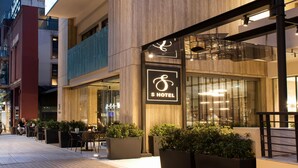 A modern hotel with a prominent sign, outdoor seating, and a well-lit entrance. - S Hotel Boutique Thessaloniki (Thessaloniki)