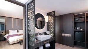 A modern hotel room with a large bed, a bathroom with a white sink and dark wood cabinets, and a separate bedroom area. - S Hotel Boutique Thessaloniki (Thessaloniki)