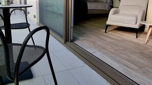 A modern apartment with a sliding glass door leading to a balcony with a dining table and chairs. - S Hotel Boutique Thessaloniki (Thessaloniki)