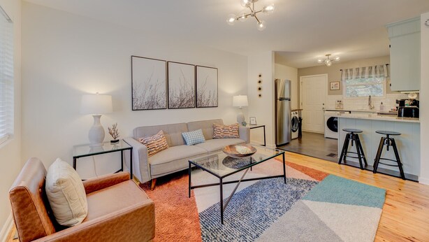 A modern living room with a sofa, coffee table, and artwork on the wall. - Modern Renovated Apartment in the ♥️ of the City (Columbia)