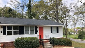 A single-story house with a red door, white siding, and a black roof. - Modern Renovated Apartment in the ♥️ of the City (Columbia)