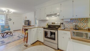 Une cuisine moderne avec des armoires blanches, un four encastré et un four à micro-ondes.