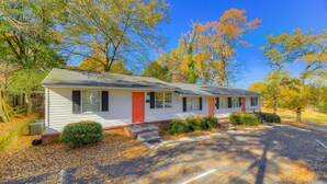 A single-story house with a red door, white siding, and a front porch. - Comfy Cozy Convenient Condo (Columbia)