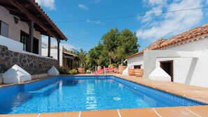 A swimming pool with a tiled edge, surrounded by buildings with white walls and terracotta roofs. - Beautiful House With Access to Pool, Tenerife, ES (San Cristóbal de La Laguna)