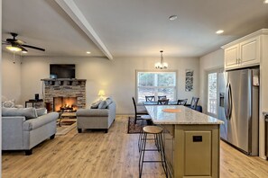 Enjoy cooking in this kitchen with a central island, refrigerator, and stone fireplace.