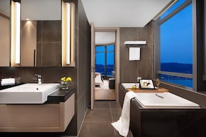 A modern bathroom with two sinks, a bathtub, and a large window offering a city view. - Southbay Hotel Residence Zhuhai (Zhuhai)