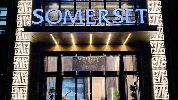 A hotel entrance with a prominent 'SOMERSET' sign, large windows, and a patterned facade. - Somerset Southbay Zhuhai (Zhuhai)