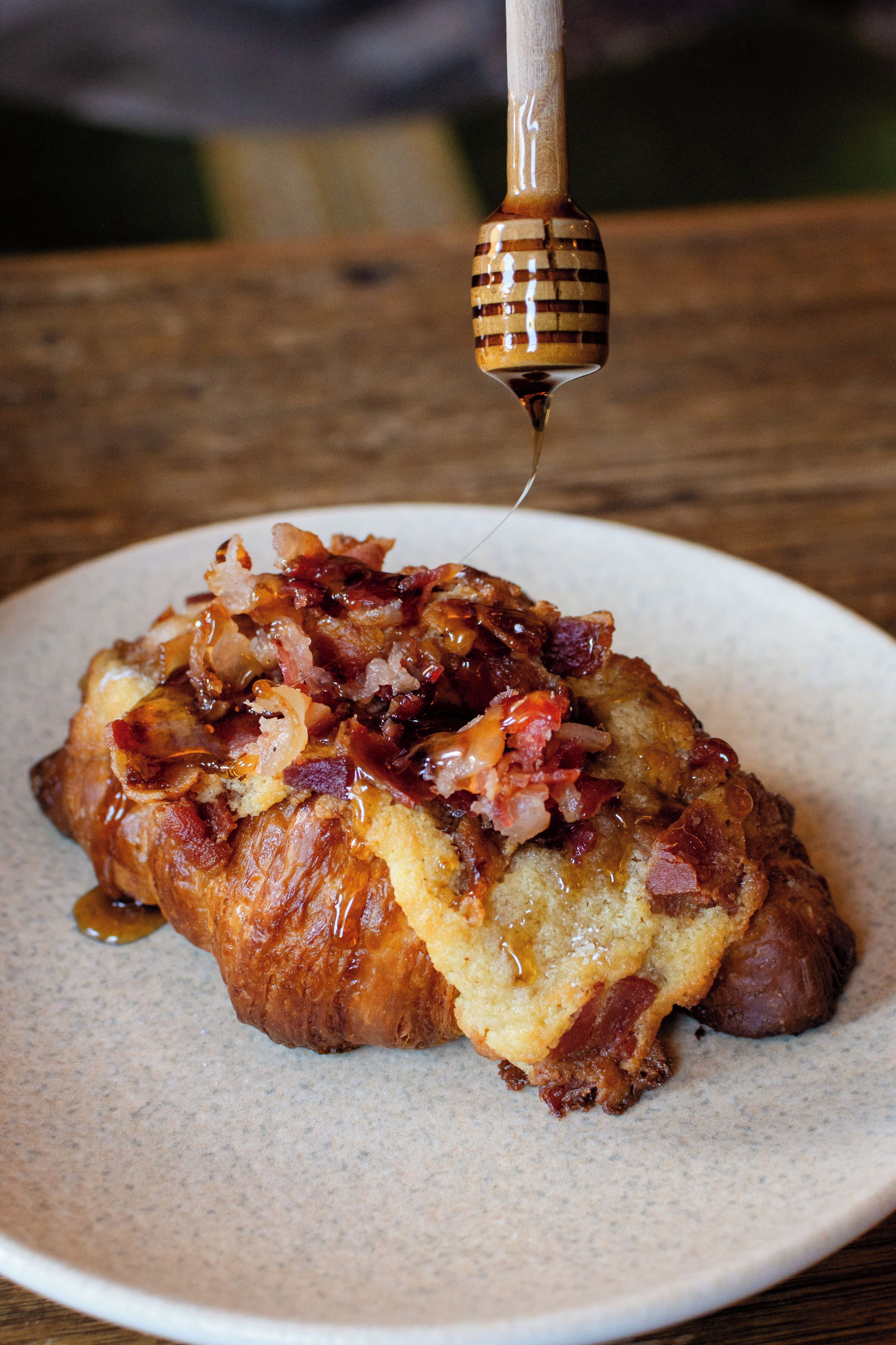 Un plato de desayuno con tocino y jarabe.